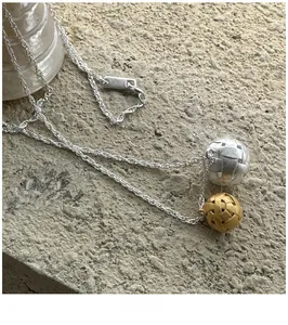 Détail du pendentif tressé bicolore argent et or mat sur une chaîne torsadée délicate
