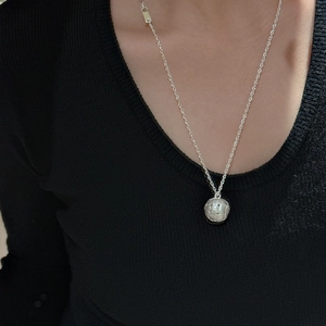 S925 sterling zilveren ketting met geweven bolvormige hanger op een zwarte gebreide trui
