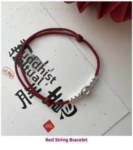 Close-up of S925 silver ingot charm on hand-woven red string bracelet for good luck