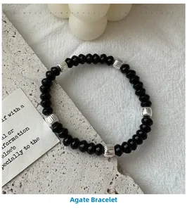 Macro shot of black agate bead bracelet with ribbed silver metal spacers on stone