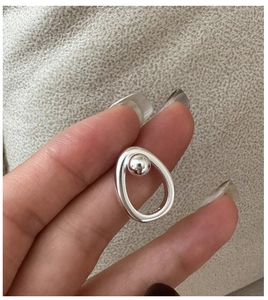 Detail of S925 sterling silver ring featuring a hollow oval frame and a solid metal ball
