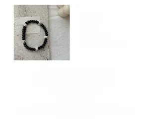 Macro detail of S925 sterling silver beaded bracelet with black agate round stones