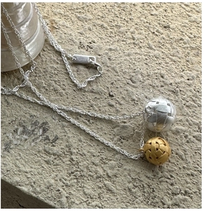 Détail d'une chaîne en argent S925 avec pendentifs boules tressées bicolores or et argent