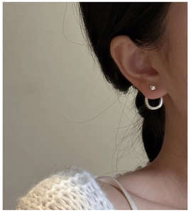 Close-up of S925 sterling silver split bead earrings worn with a white knit sweater