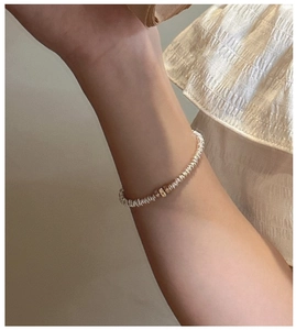 Close-up of S925 sterling silver chain bracelet with gold bead accents on a female wrist