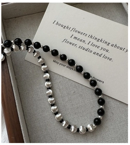 Close-up of S925 silver necklace with brushed metal beads and glossy black round stones