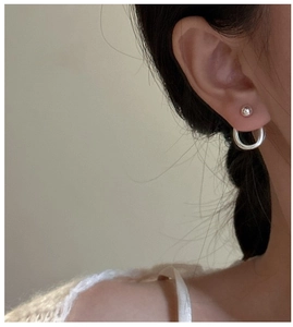 Detail of S925 sterling silver ball stud and polished hoop earring set on model