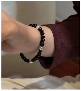 Close-up of S925 sterling silver beaded bracelet with black stones and textured metal spacers