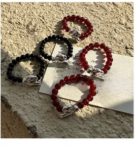 Détail macro de bagues élastiques en argent S925 avec perles noires, rouges et teckel