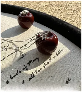 Close-up of S925 sterling silver red apple pendant with silver leaf on a bead chain