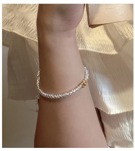 Close-up of S925 silver beaded bracelet featuring a gold-tone M letter charm pendant