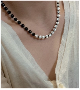 Detail of S925 silver necklace featuring black beads and textured metallic spheres