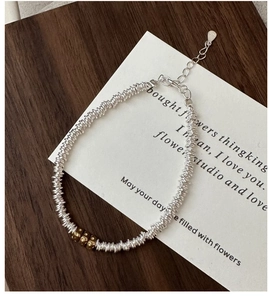 Detailed macro of S925 sterling silver mesh bracelet with golden bead accents and S925 stamp
