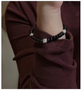 Detailed shot of S925 silver textured beads and black pearls on a minimalist bracelet