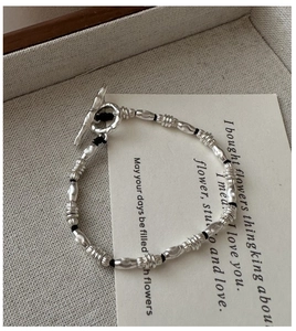 Detailed close-up of S925 silver beaded bracelet with OT toggle clasp and woven cord