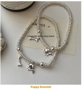 Detailed macro shot of S925 sterling silver puppy and bone charms on beaded bracelets