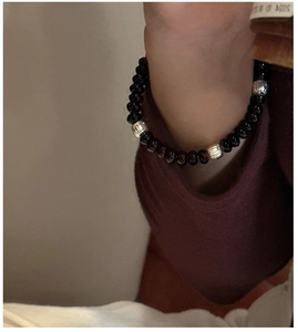Detail of minimalist beaded bracelet with black stones and silver textured accents