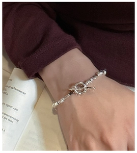 Detail of silver S925 beaded bracelet with stylish OT toggle clasp on wrist