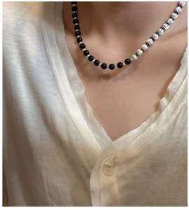 Detail of S925 silver necklace featuring black beads and brushed cat-eye white beads