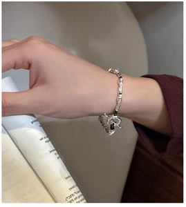 Detail of S925 sterling silver beaded bracelet with OT toggle clasp on a soft background