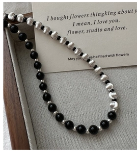 Detailed shot of retro S925 silver brushed beads and black glossy cat eye necklace