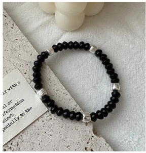 Detail of beaded bracelet with black obsidian gems and textured silver metal spacers