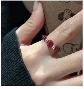 Macro shot of S925 silver red agate bead ring with carved center bead on finger