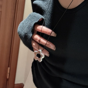 Collier minimaliste en argent 925 avec pendentif fleur noire porté par un mannequin