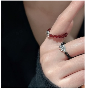 Détail de bagues extensibles en perles rouges et noires avec breloques teckel en argent 925