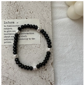 Detail of beaded bracelet with black faceted beads and textured silver spacers