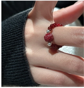 Macro shot of red agate beaded ring with carved lotus flower and silver accents