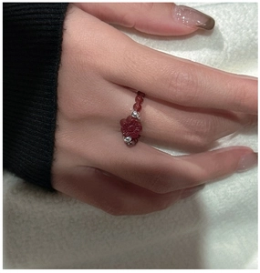 Detail of S925 silver ring with red agate beads and a hand-carved floral charm