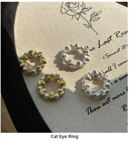 Close-up of 925 silver beaded rings with cat eye texture on a vintage cloth background