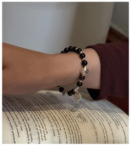 Dettaglio del bracciale in argento S925 con perline occhio di tigre e ciondolo inciso