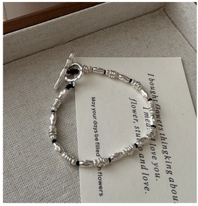Detailed close-up of S925 silver beaded bracelet with vintage toggle clasp on display