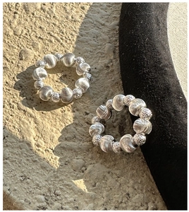 Detail of 925 sterling silver beaded rings with spiral and hammered textures on stone