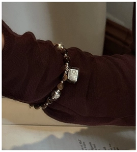Dettaglio ravvicinato del bracciale con perline occhio di tigre e ciondoli in argento