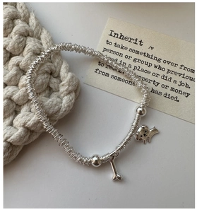 Detail of S925 sterling silver beaded bracelet featuring cute puppy and bone charms