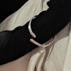Minimalist S925 sterling silver cuff bracelet with brushed texture worn over black sleeve