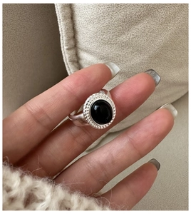 Detail of 925 sterling silver ring with oval black onyx and twisted rope texture border