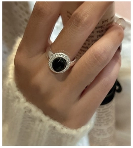 Macro shot of a 925 sterling silver ring with an oval black agate stone and rope edge