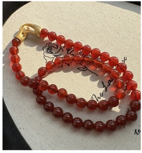 Macro detail of red agate beads necklace with vintage gold metal hook clasp closure