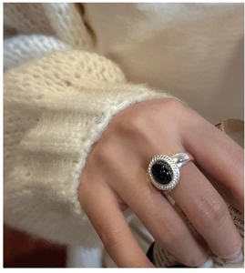 Detailed shot of a vintage 925 silver ring with oval black onyx and textured double border