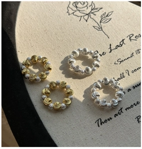 Macro detail of 925 sterling silver beaded rings with CNC engraved texture in gold and silver