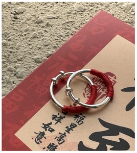Detail of S925 sterling silver rings with red thread weaving on festive calligraphy card