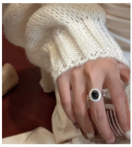 Close-up of vintage 925 silver ring with oval black agate on a model's hand