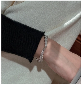 Détail du bracelet élastique en perles d'argent S925 porté au poignet d'un mannequin