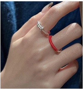 Close-up of S925 silver knot ring and red string braided band on model fingers