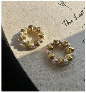 Macro shot of 925 sterling silver and gold beads with CNC texture and cat eye finish