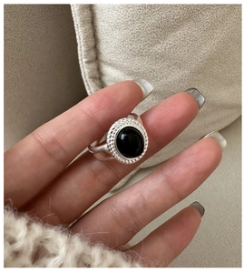 Detailed close-up of a vintage 925 silver ring with oval black onyx and rope texture